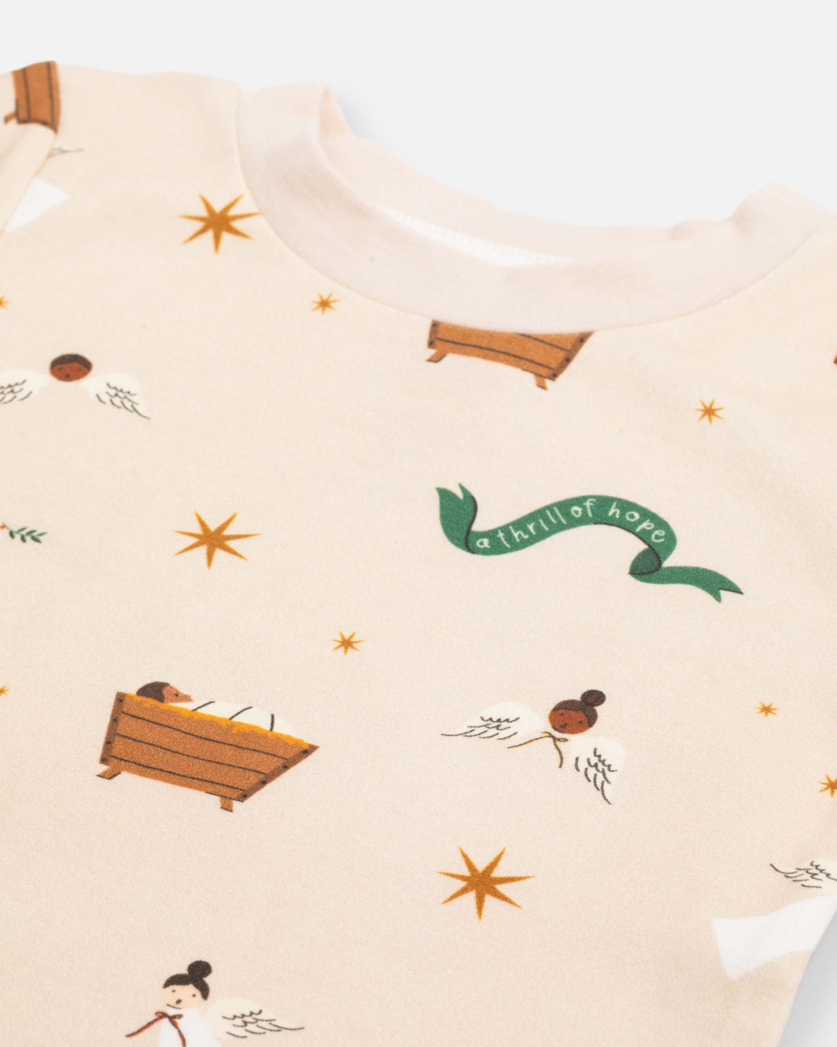 Children’s Christmas pajamas—sleeper and long john styles—with illustrations of angels, baby Jesus in the manger, and doves.