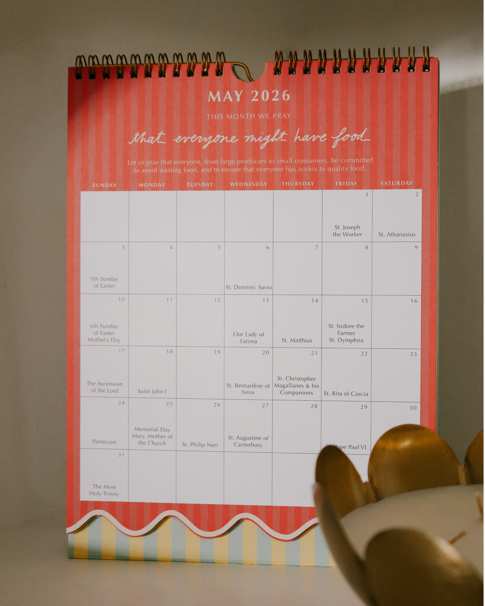 2026 Catholic liturgical calendar with colorful stripes, monthly prayers by Pope Francis, and all feast days and US holidays. Available as wall calendar or wall + desk stand combo.