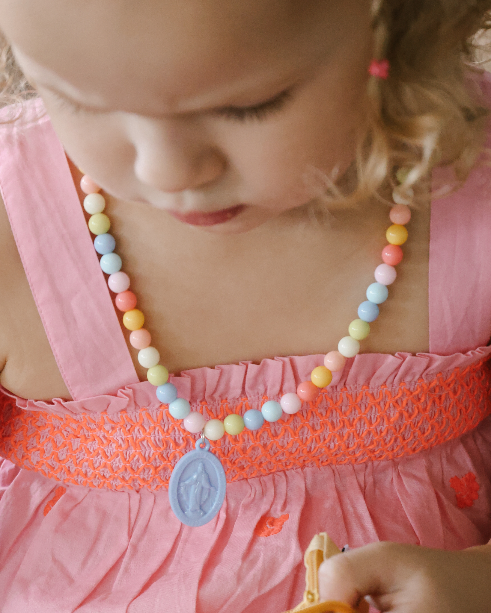 Children’s Miraculous Medal necklace with soft blue medal and colorful plastic beads on elastic strand. Christian kids’ jewelry for Marian devotion, First Communion, or faith-based gifts, reminding children of Mary’s protection and intercession.