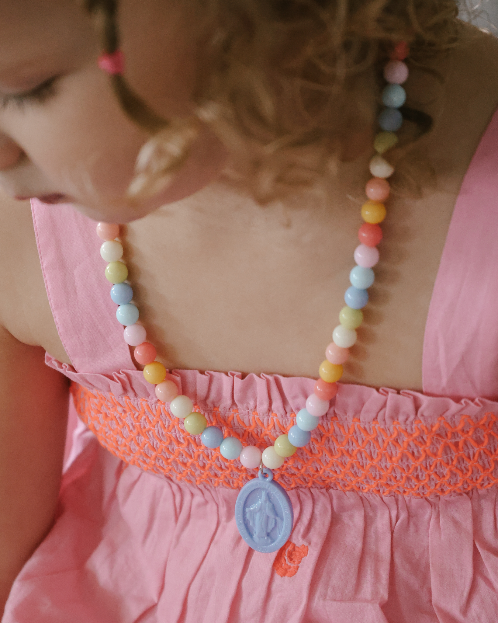 Children’s Miraculous Medal necklace with soft blue medal and colorful plastic beads on elastic strand. Christian kids’ jewelry for Marian devotion, First Communion, or faith-based gifts, reminding children of Mary’s protection and intercession.