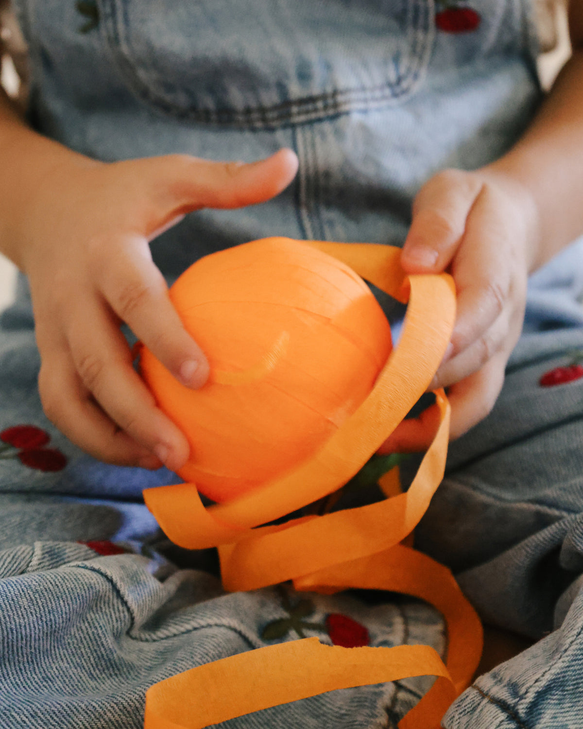 Unwrapping a St. Nicholas Orange Surprise Ball to find hidden treasures for St. Nicholas Day