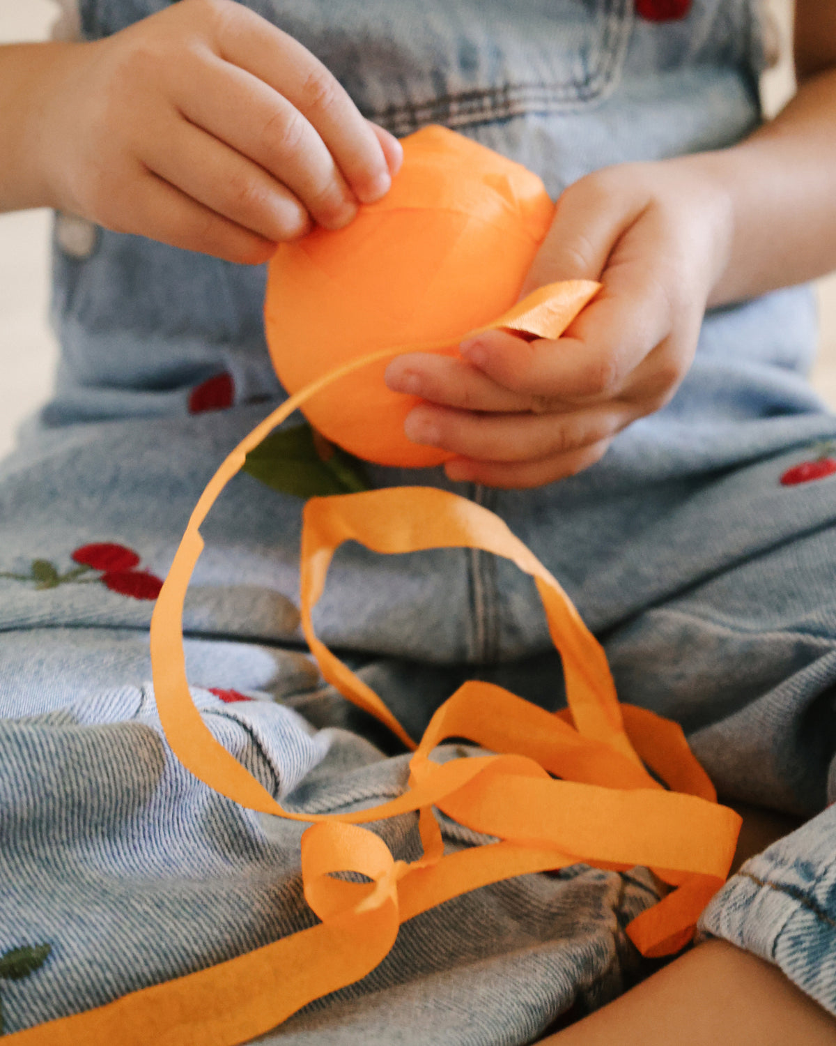 Child peeling crepe paper ribbon off a St. Nicholas surprise orange