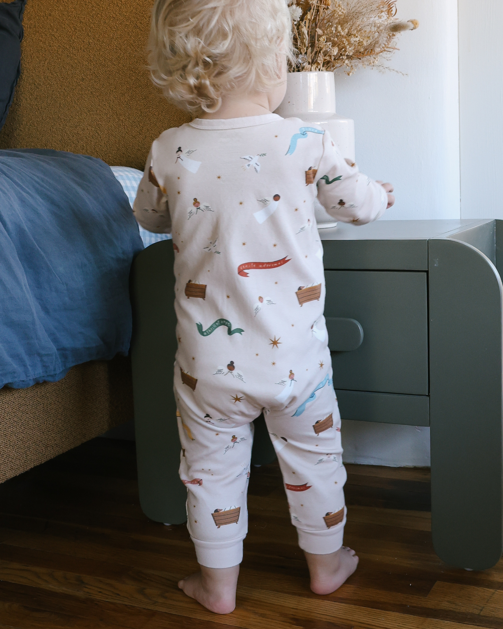 Children’s Christmas pajamas—sleeper and long john styles—with illustrations of angels, baby Jesus in the manger, and doves.