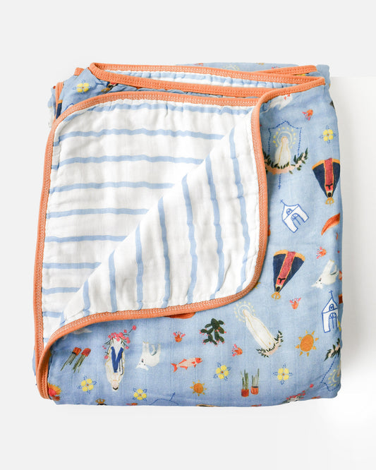 A folded Be A Heart blue Marian Deluxe Muslin Baby Blanket, showcasing intricate Marian designs on soft, breathable muslin fabric.