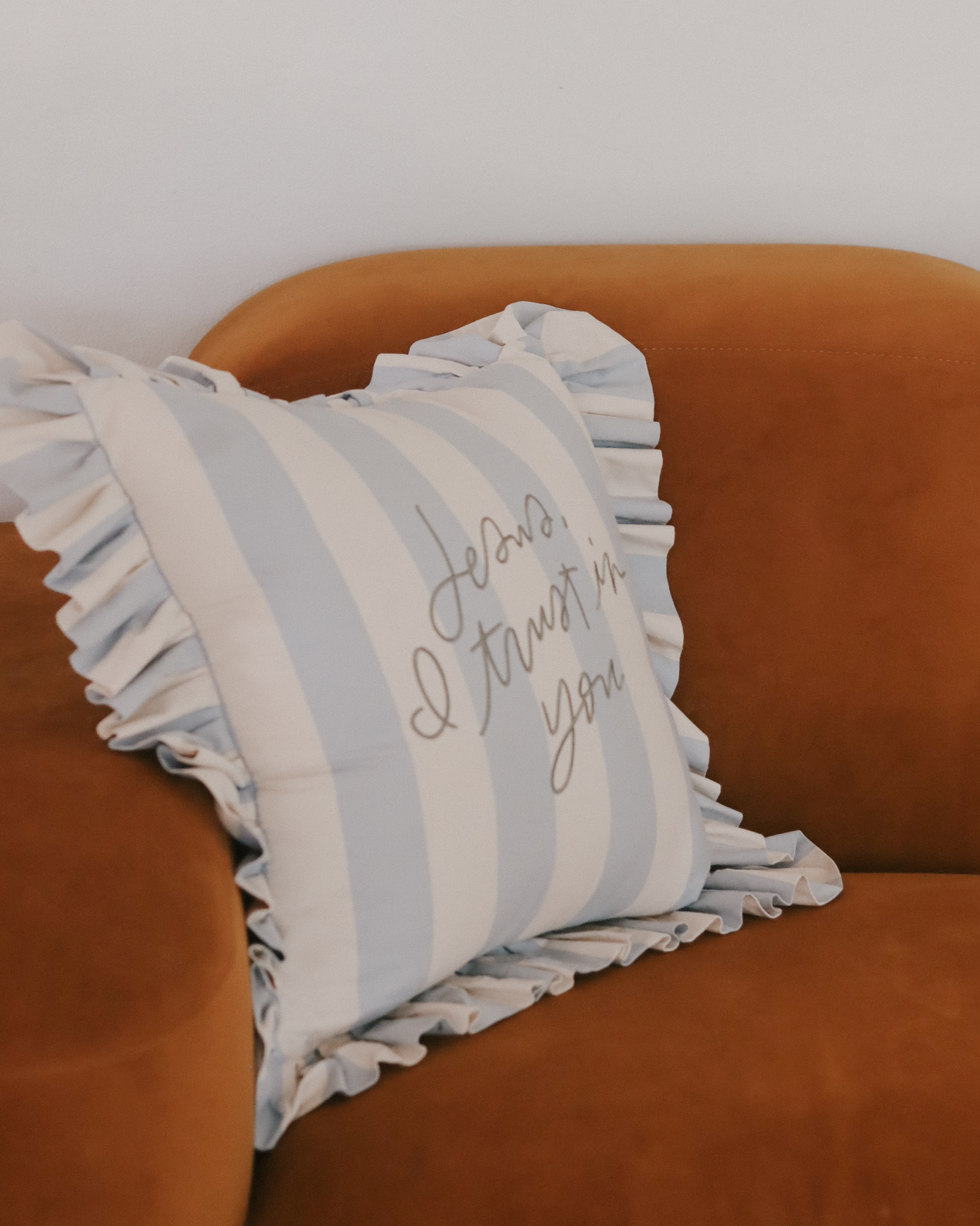 Light blue and cream striped ruffle pillow with sage embroidered ‘Jesus, I trust in You’ design, inspired by Divine Mercy devotion. Christian home décor accent pillow with cotton insert and 22-inch ruffled edge—perfect faith-based gift and prayer reminder for the home.