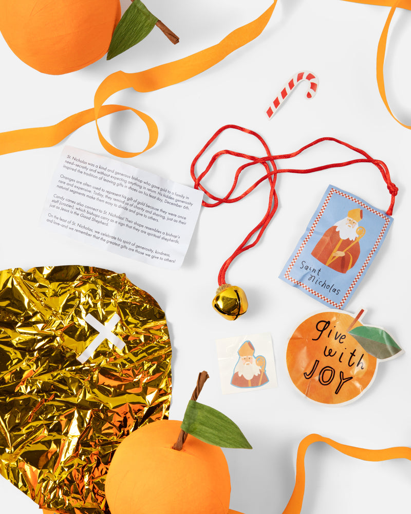 St. Nicholas Orange Surprise Ball contents: prayer card, jingle bell necklace, stickers, tattoo and gold foil bishop mitre