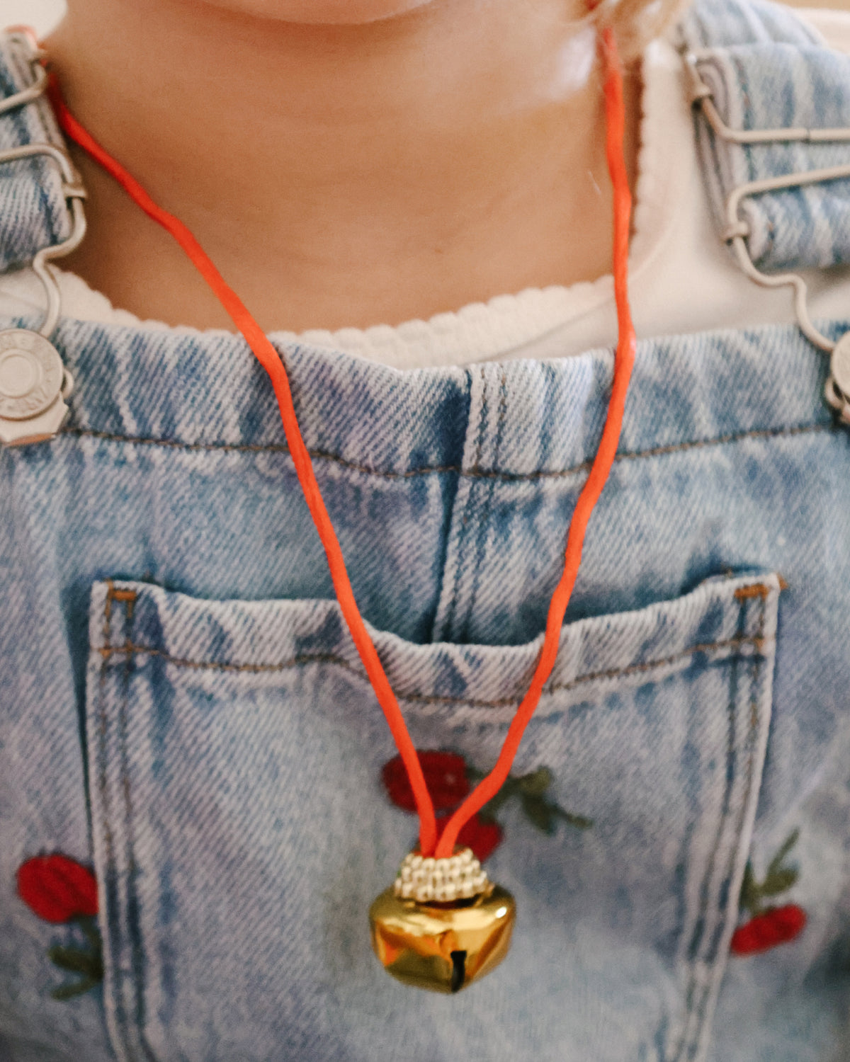 Child wearing the jingle bell necklace found inside the St. Nicholas Orange Surprise Ball