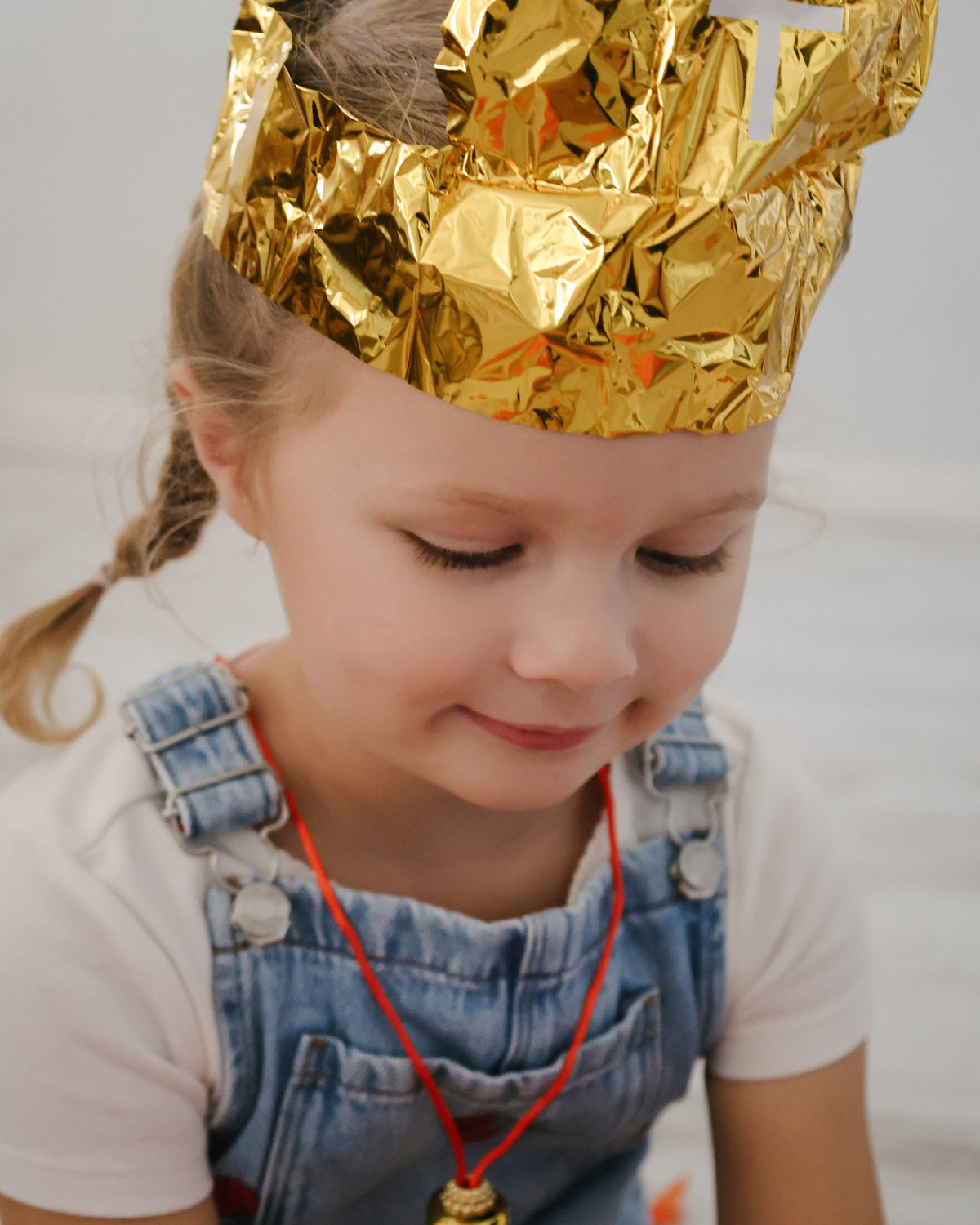 Girl wearing the gold foil bishop's mitre from the St. Nicholas Orange Surprise Ball