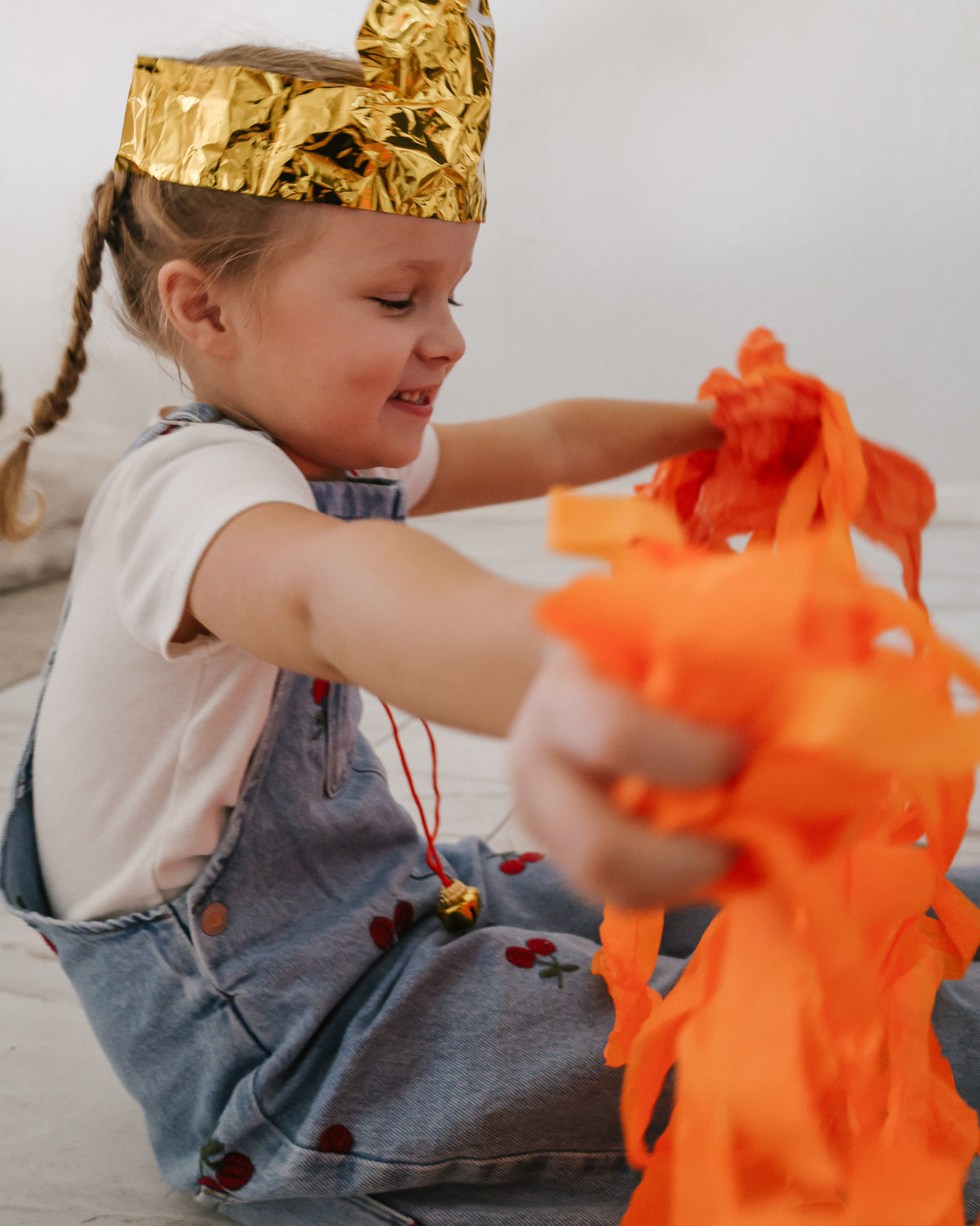 Girl in a gold mitre tossing crepe paper streamers after opening her St. Nicholas surprise ball